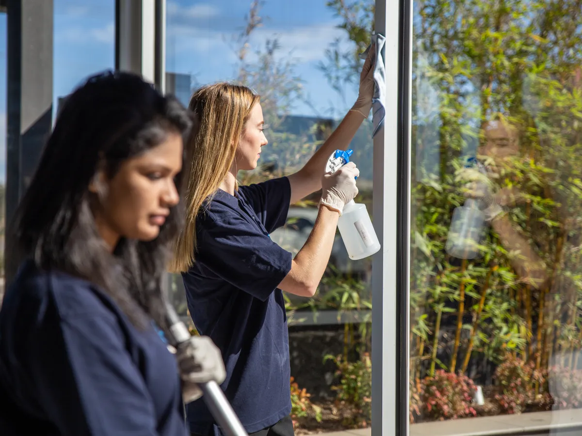 Two Star Shining cleaners squeegeeing office windows